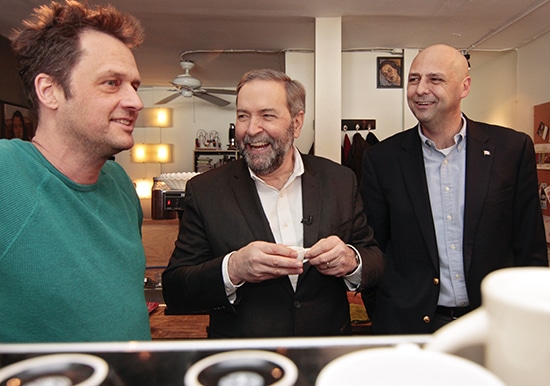James Feistner, owner of Grinder Coffee, gets a laugh from NDP leader Thomas Mulcair, centre, and local Beaches-East York MP Matthew Kellway, right, after Mulcair pressed and poured his own espresso in the Upper Beach café on Feb. 10. PHOTO: Andrew Hudson