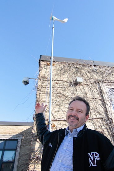 Neil McNeil High School teacher Joe Ferro shows the new wind turbine installed above the school's technology class this fall. PHOTO: Andrew Hudson