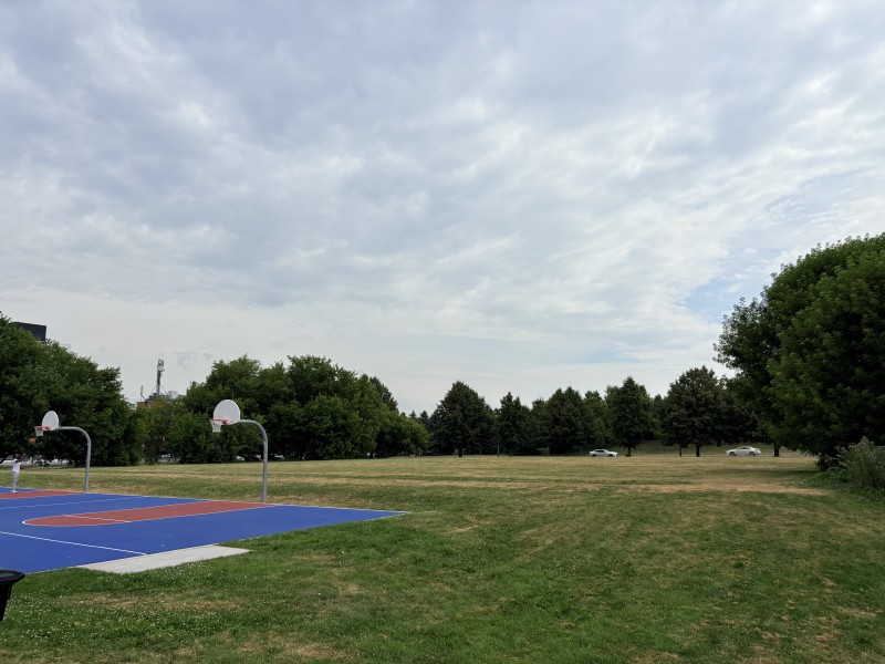 The basketball courts at Ashbridges Bay Park are located near the future site of new pickleball courts. In the distance, traffic moves along Emdaabiimok Avenue, formerly Lower Coxwell Avenue.